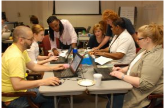 students doing group work with laptops at a table